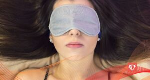 kobieta śpiąca w łóżku z szarą maską na oczach